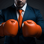 Businessman wearing orange boxing gloves and a suit